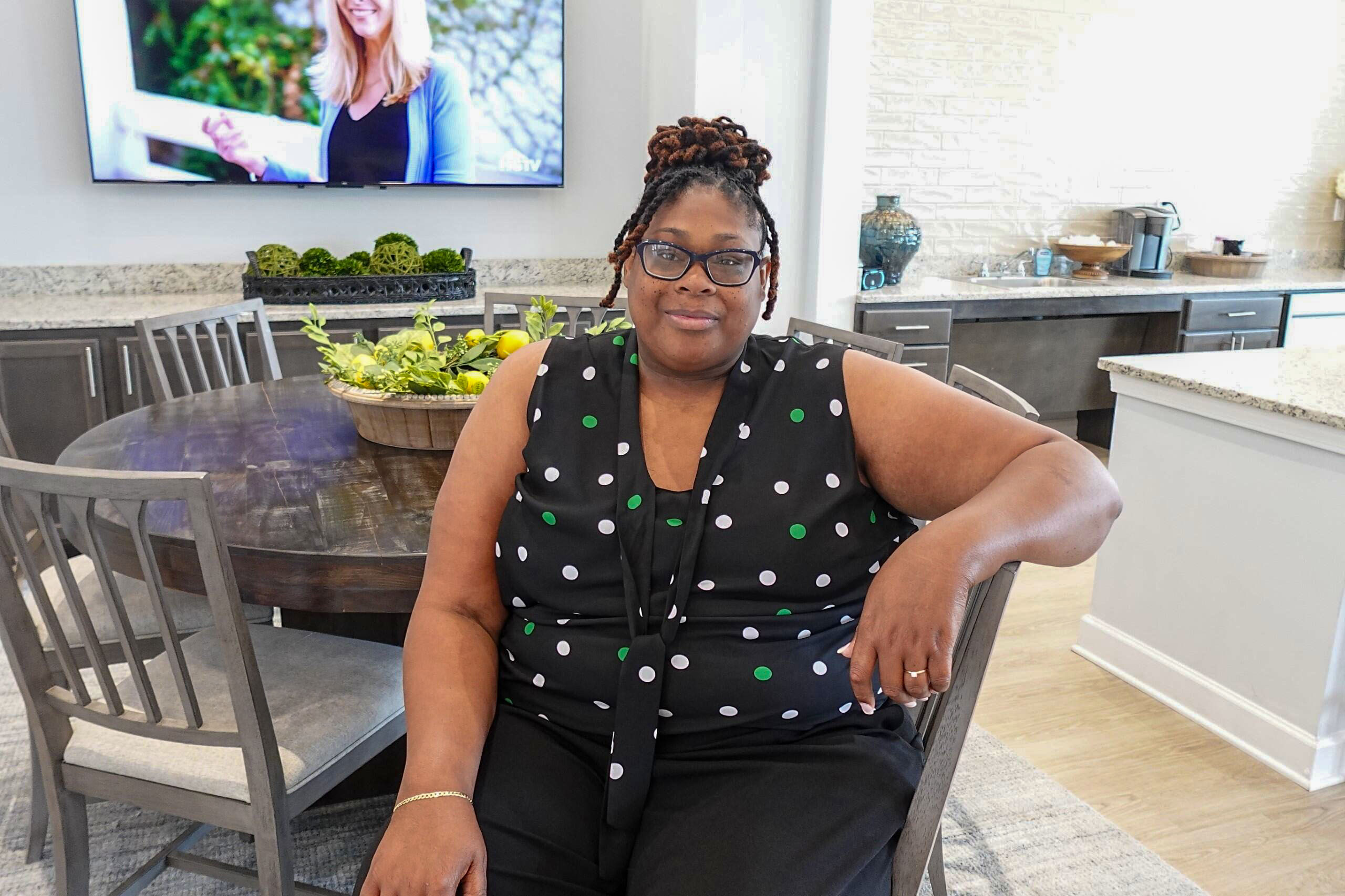 Brandi/The Dapper Realtor sitting in a luxury home. This home is part of her premiere home-buying service, Dapper Dwellings. 